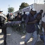 A U.N peacekeeper from Jordan kicks a Haitian man as they disperse people asking for food from around the airport in Port-au-Prince January 18th. 